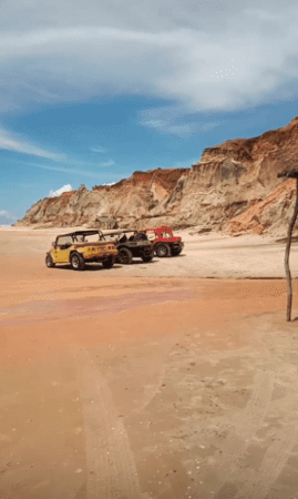 Buggys na praia com falésias atrás na Praia das Fontes