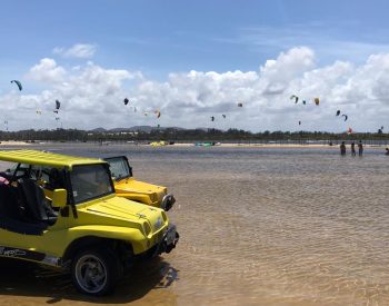 Buggys na lagoa do Cauipe e praticantes de kitesurf no fundo