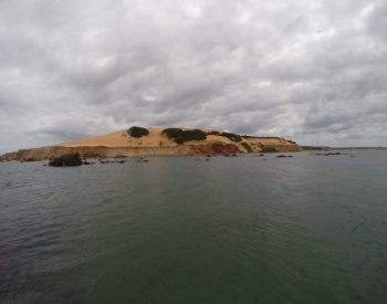 Mar com duna e falésia na beira do mar