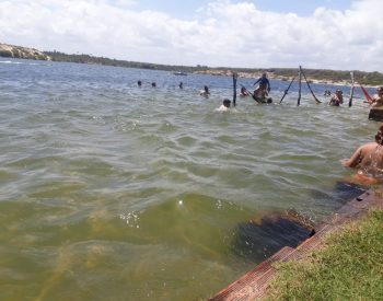 Pessoas tomando banho de lago e redes dentro da água