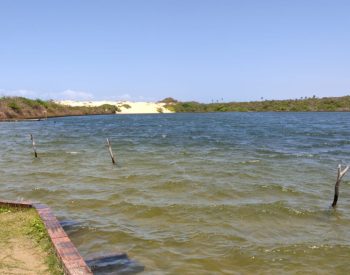 Lagoa com mata e duna ao fundo