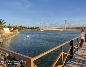 Pier em rio em Mundaú com geradores eólicos de fundo