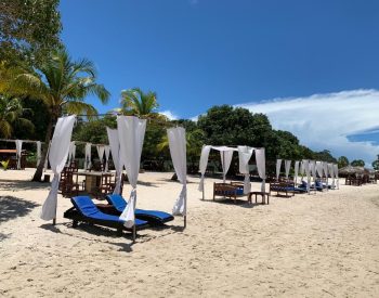 Várias camas na areia na beira do lago