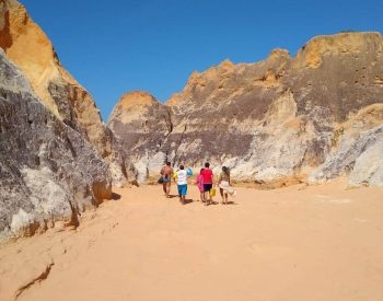 Gente caminhando pelas falésias de Morro Branco