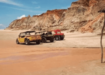 Buggys na praia com falésias atrás na Praia das Fontes