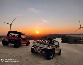 Dois buggys numa duna em Mundaú com pôr do sol