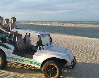 Três mulheres passeando de buggy na praia